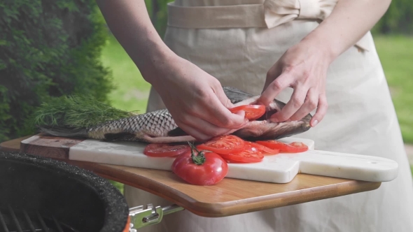 Housewife Places Sliced Tomatoes Into the Raw Fish Before Cook It, Carp Fish on the Board, Cooking alt