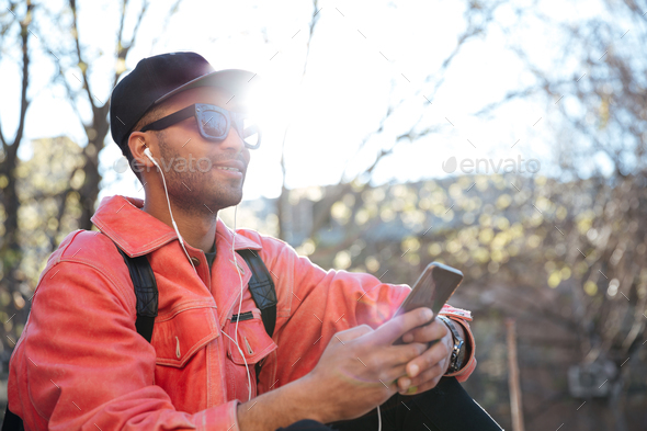 Handsome smiling young african man outdoors using mobile phone. - Stock Photo - Images