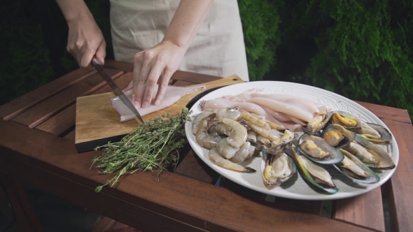 The Cook Is Slicing Raw Calamari on the Wooden Board, Chef Prepares Seafood for Cooking Asian