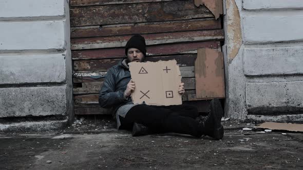Homeless Man Sits Holds Piece of Cardboard with Markers for Planar Tracking alt