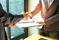 Businessmen are shaking hands and exchanging business documents. - PhotoDune Item for Sale