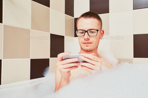 Man using mobile phone in the bathroom