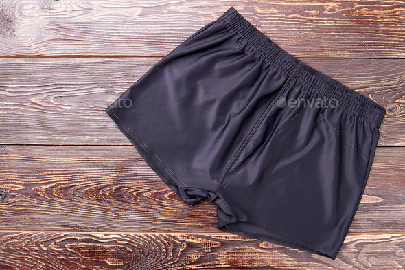 Black running shorts, wooden background
