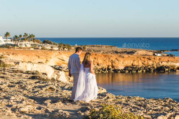 Romantic dating. Young loving couple walking together by the beach enjoying sea