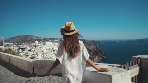 Young Sexy Woman Is on the Greek Island Santorini in a White Dress and and Straw Hat White Greek alt