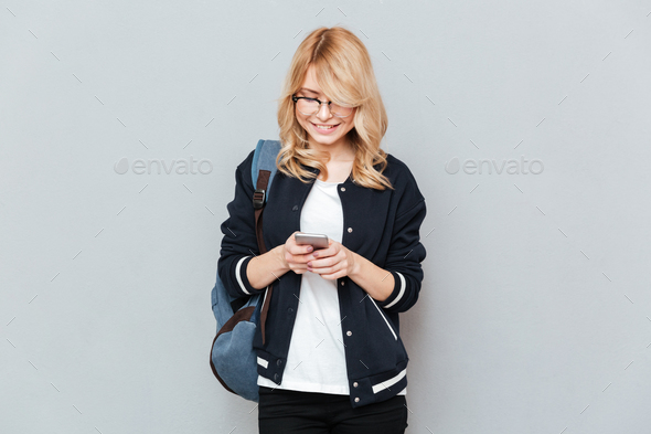 Female student writing message on smartphone