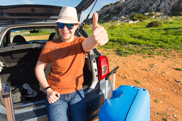 Summer, holiday, trip and vacation concept - Man near the car showing thumbs up and ready to travel