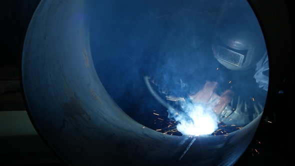 Welder Inside A Big Pipe Welding The Seam To Create One Continuous Section Of Pipe