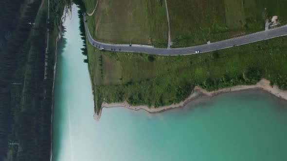 Aerial above road along shore of Frumoasa Dam reservoir. Romania. Vertical video alt