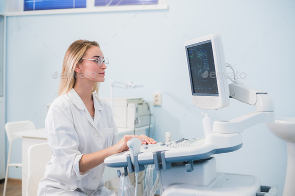 Smiling doctor, ultrasound. The doctor performed an ultrasound. Stock Photo by romankosolapov