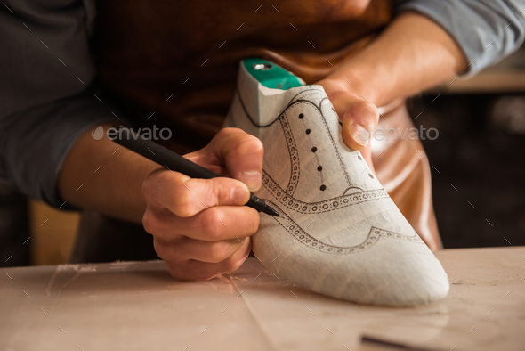 Close up of a male shoemaker drawing design