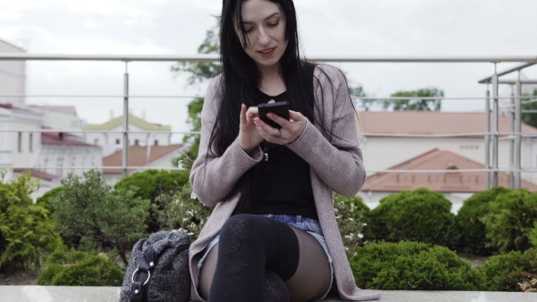 Beautiful Woman Uses a Smartphone