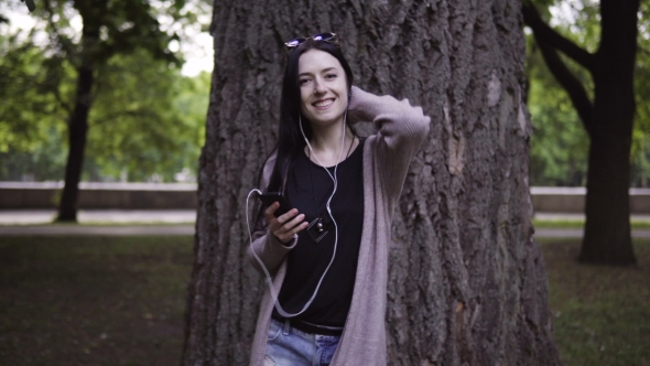 Happy Woman in Headphones Is Dancing with Smartphone