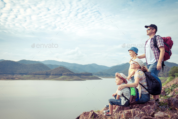 Happy family standing near the lake.