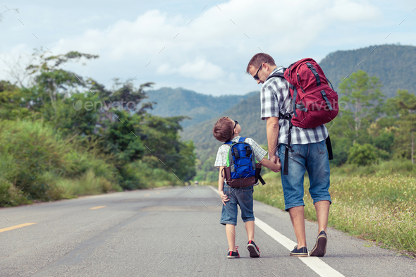 Father and son walking on the road. - Stock Photo - Images
