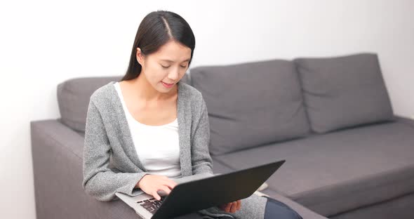 Woman working on notebook computer at home alt