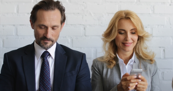 Group Of Business People Using Cell Smart Phones Sitting In Line, Mix Race Businesspeople Team