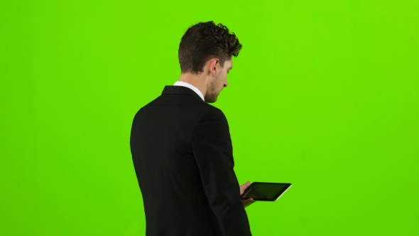 Businessman Walks, Thumbs a Notebook, and Makes a Selfie. Green Screen alt