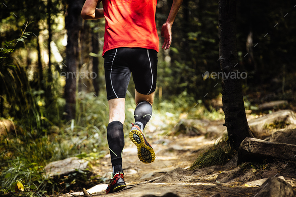 Marathon Runner Running on Stones in Forest