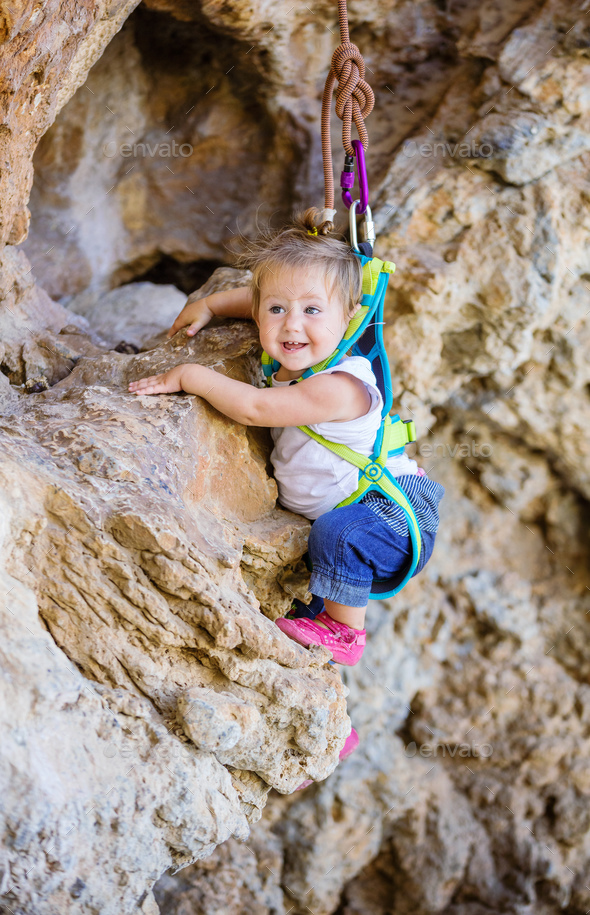 Happy little girl climbing on cliff Stock Photo by photobac PhotoDune