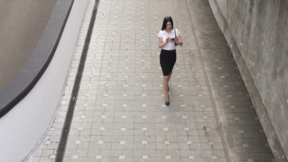Business Woman Walking and Using a Smart Phone