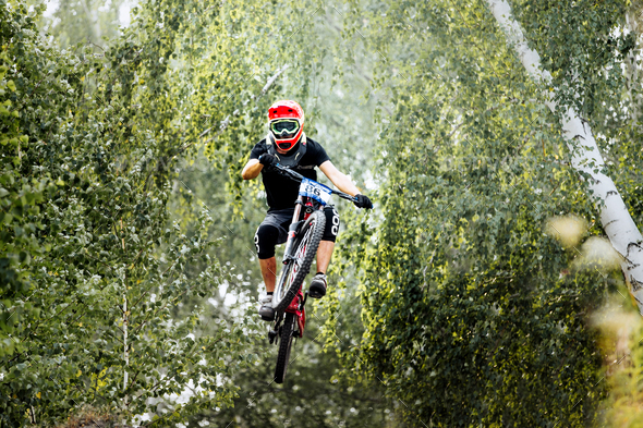 Athlete Extreme Jump on Bike in Forest
