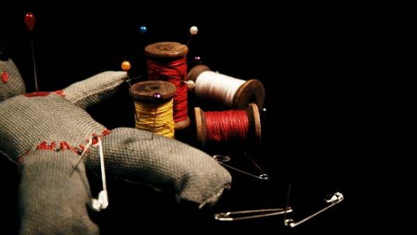 Stitched Voodoo Doll for Ritual on a Black Background with Threads and Needles alt