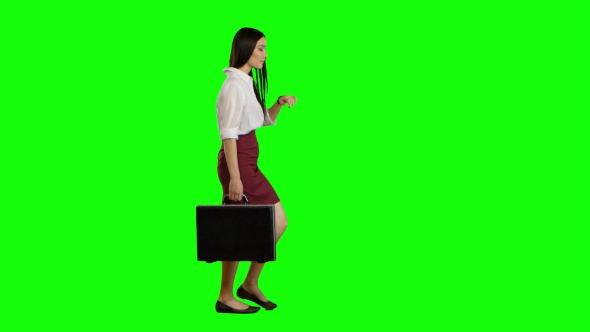 Asian Girl Looks on the Road Holding a Briefcase in Her Hands. Green Screen alt