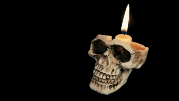 Skull with a Burning Candle on a Black Background alt