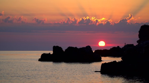 Sunset Over the Sea with Rocks and Clouds