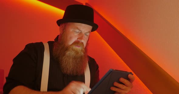 Bearded Man is Very Angry While Surfing the Internet Using Tablet