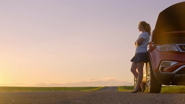 Girl Near the Car on A Sunset Background alt