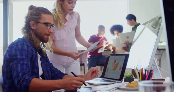 Executives discussing over desktop pc at desk 4k alt