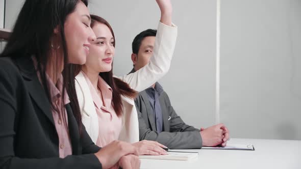 A female trainer raised her hand to ask a question at a corporate seminar. alt