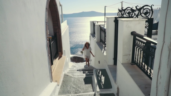 Young Sexy Woman Is on the Greek Island Santorini in a White Dress and and Straw Hat White Greek alt