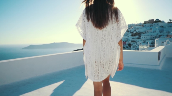 Young Sexy Woman Is on the Greek Island Santorini in a White Dress and and Straw Hat White Greek alt