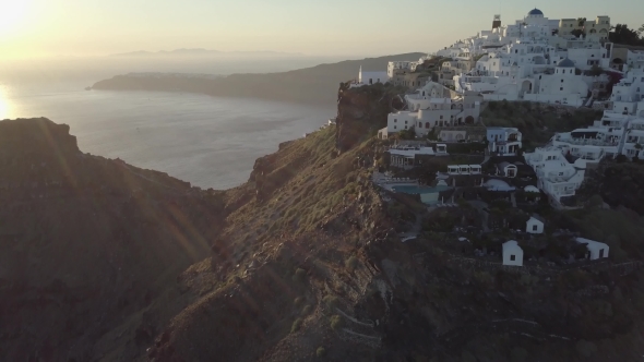 Aerial view of greek island Santorini with white houses, blue roofs at sunset and in the daylight