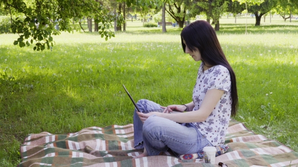 Woman Using Laptop in Park