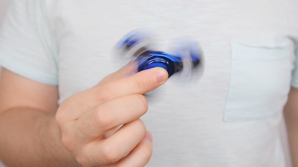 Man Holding and Playing with Fidget Spinner alt
