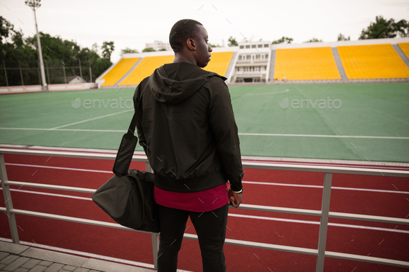 Back view of a young african sportsman standing at the stadium