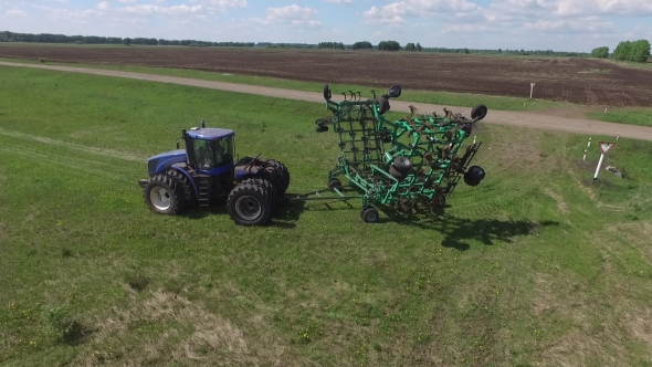 Tractor with Planter Sows Black Boundless Field
