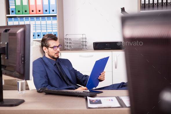 Businessman in office with his feet on the table