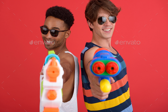 Handsome two men friends with water toy guns