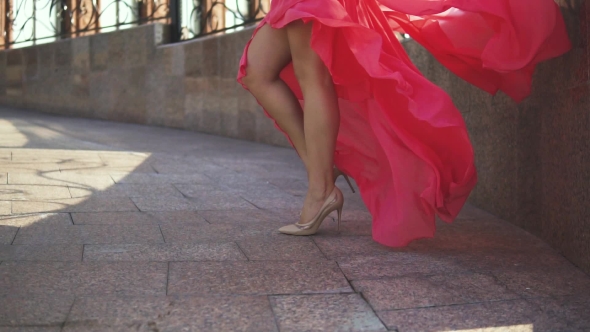 Sexy Female Legs in High-heeled Shoes. The Girl in the Evening Dress Is Walking Down the Street
