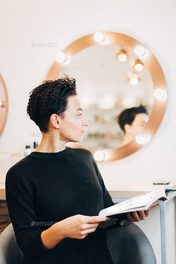 Attractive woman at the mirror in beauty studio - Stock Photo - Images