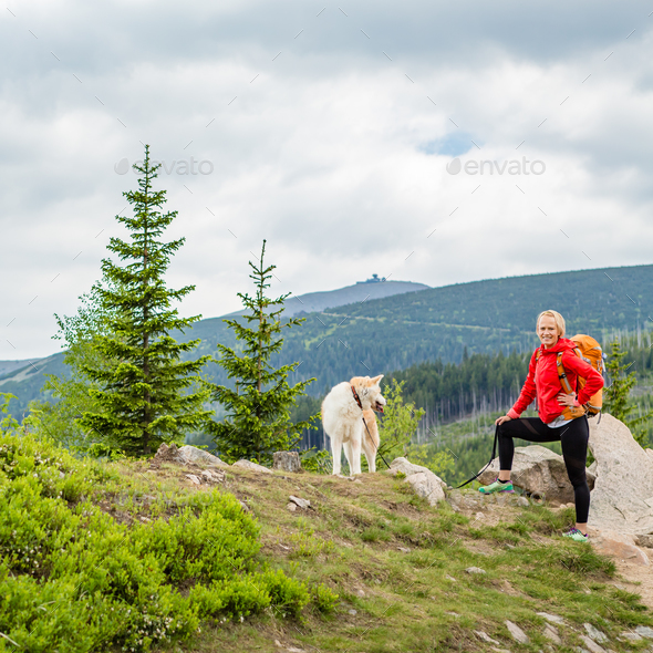 Happy woman hiking walking with dog in mountains, Poland