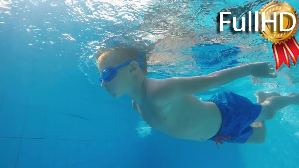 Boy Dives Under the Water in a Swimpool