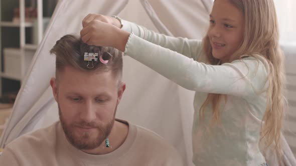 Daughter Making Ponytails on Her Joyful Fathers Hair alt