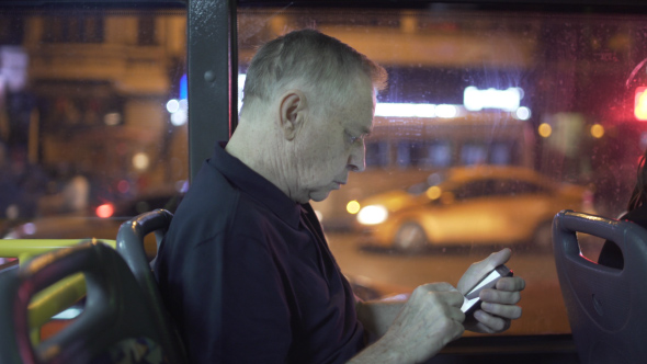 Senior Traveling by Bus and using Smartphone to navigate and plan his Rout