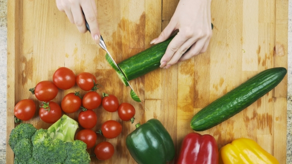 Slicing Cucumber on Wooden Cutting Board